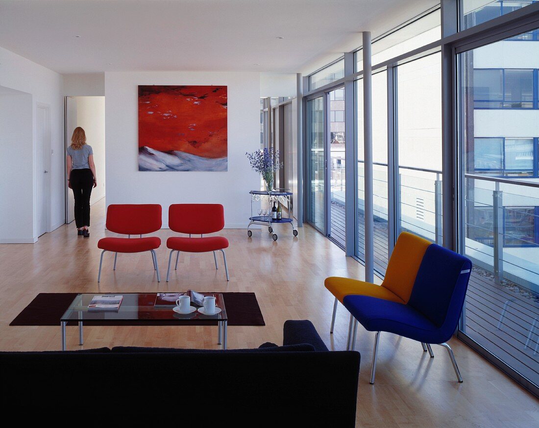 Espressopause im modernen Wohnraum mit farbigen Sesseln