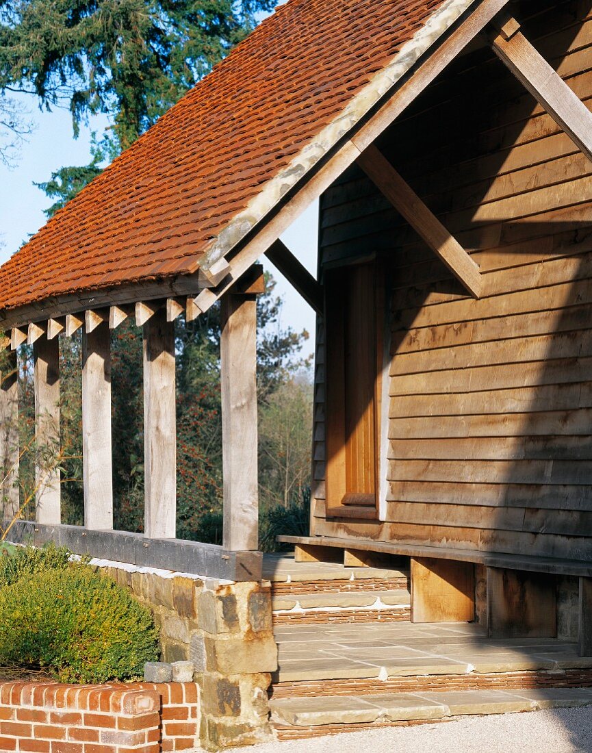 Rustikales Vordach mit Ziegeln am Holzhaus