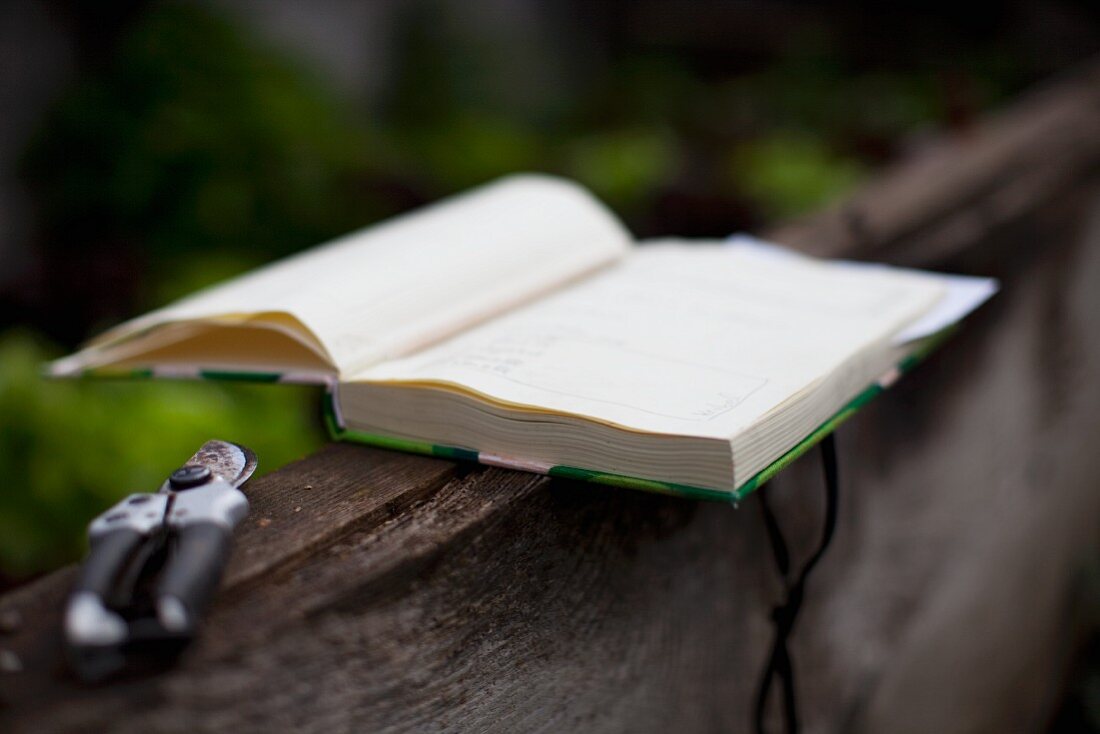A book and pruning shears in a garden