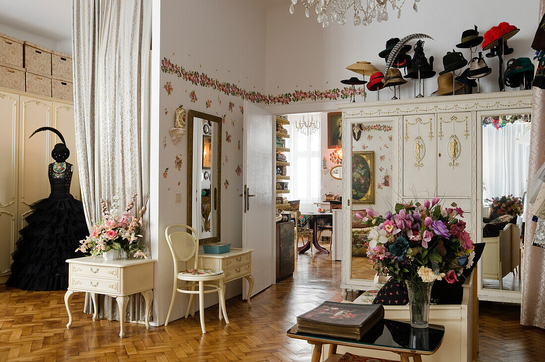 Room with lots of hats, vintage furniture and herringbone parquet flooring