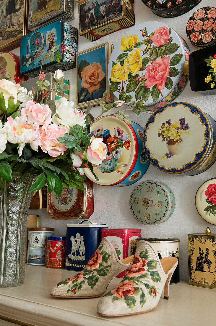 Wall decoration made of vintage tins and shoes with floral pattern