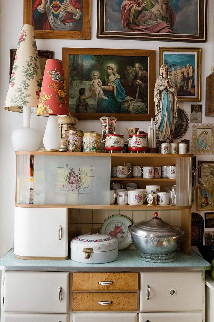 Vintage kitchen cabinet with religious motifs and collector's items