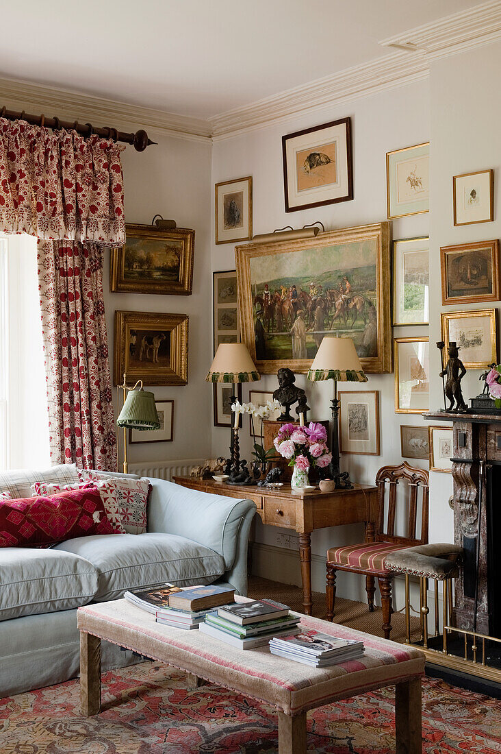 Living room with antique furniture, framed artwork and floral accents