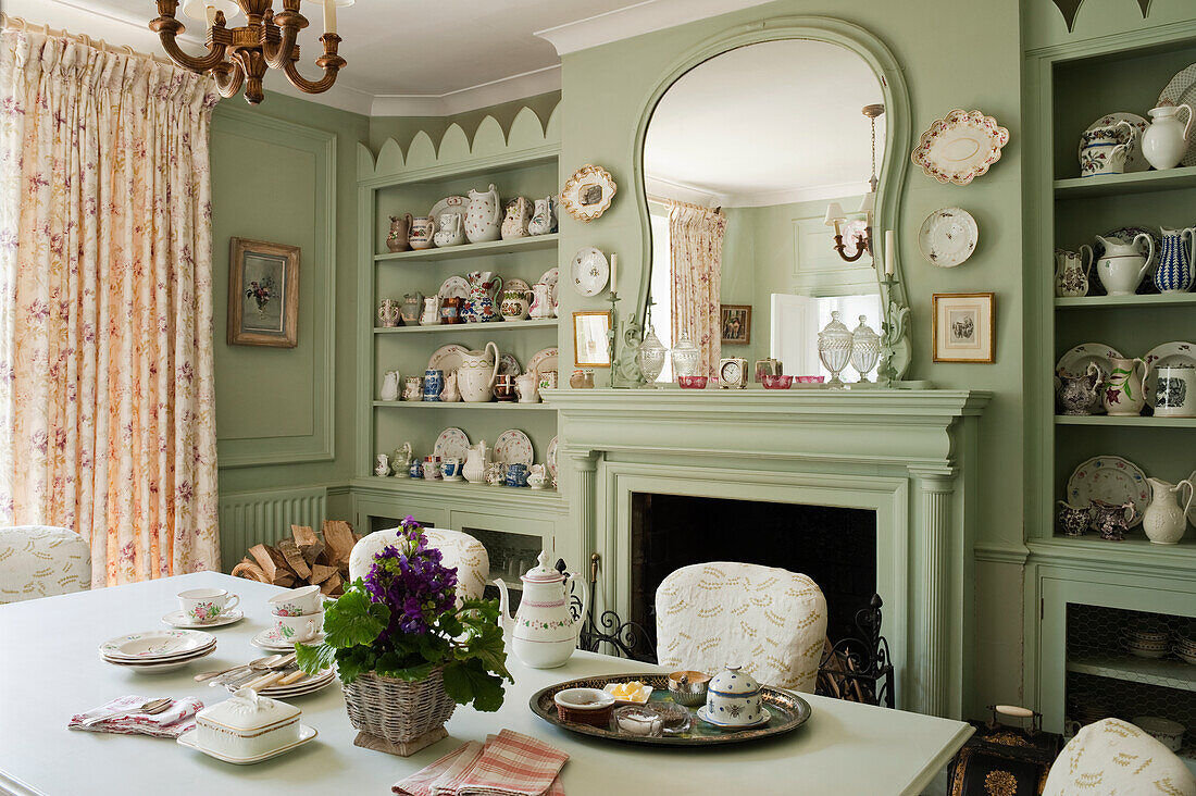 Country-style dining room with green-painted walls and open fireplace