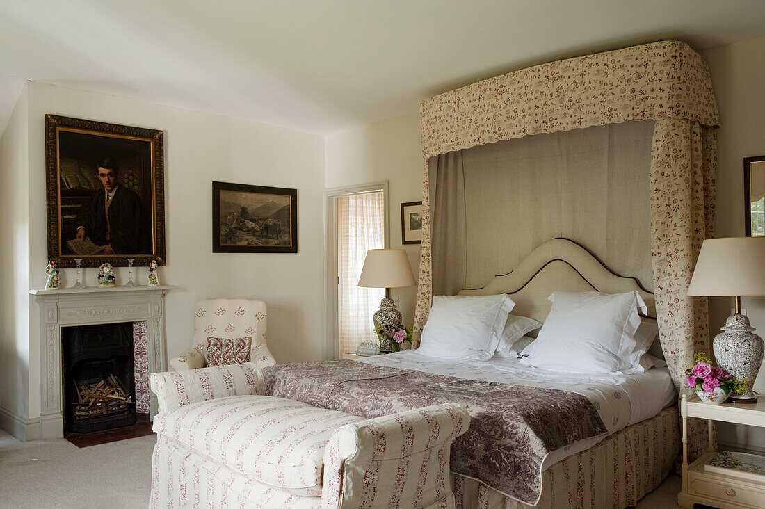 Bedroom with bed, bed bench, armchair and fireplace