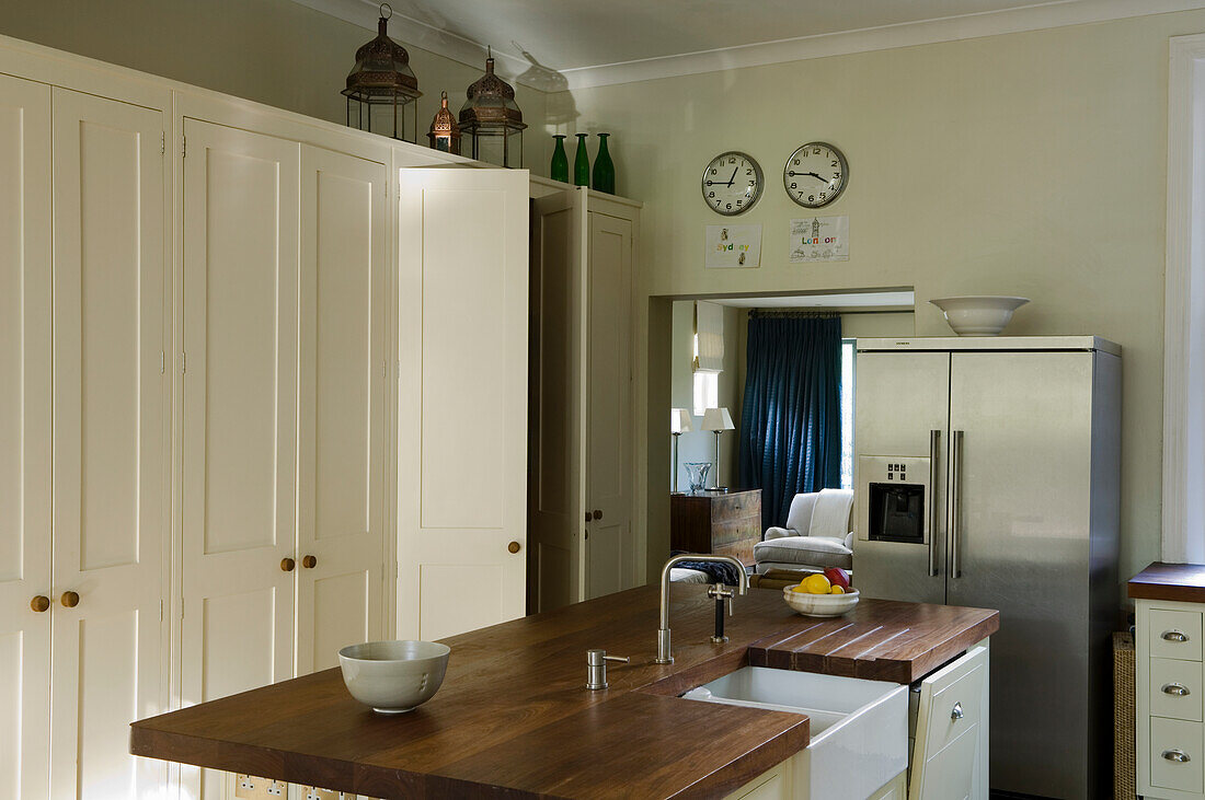 Kitchen with wooden worktop, white sink and stainless steel fridge