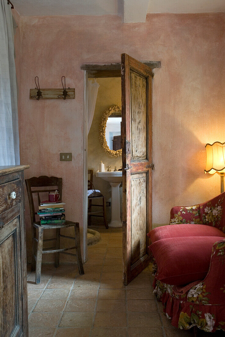 Rustikal gestaltetes Wohnzimmer mit Blick ins angrenzende Badezimmer