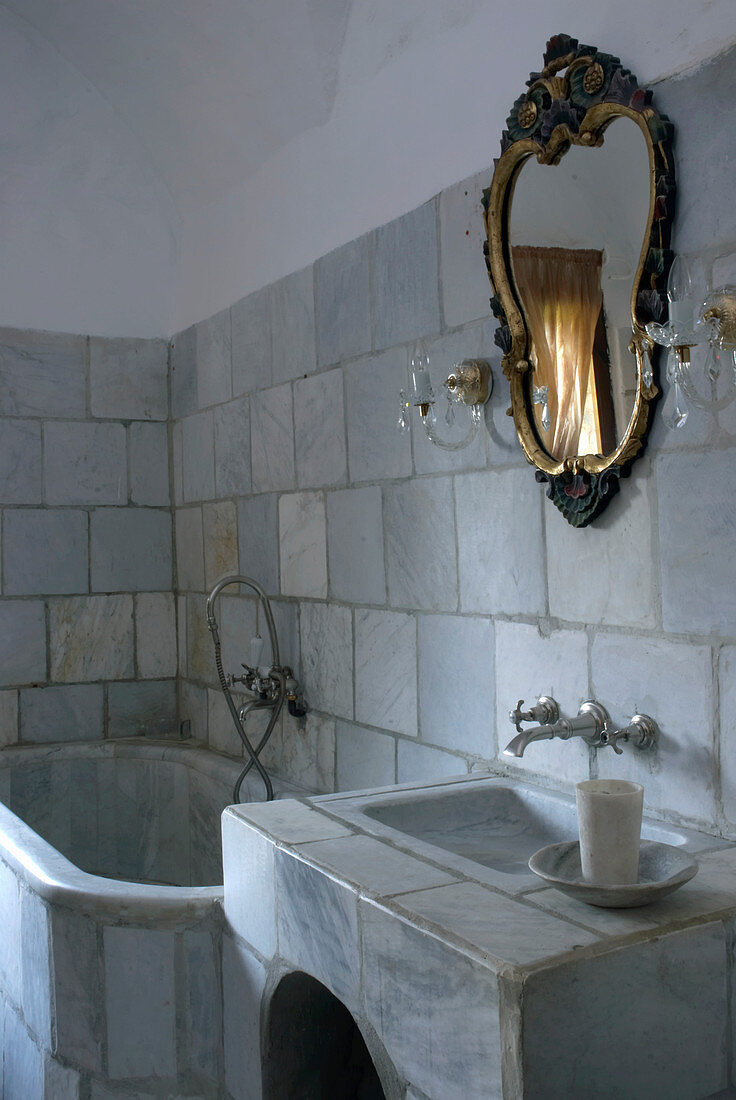 Fliesen aus recyceltem Stein, Waschbecken und Badewanne aus Marmor im Badezimmer