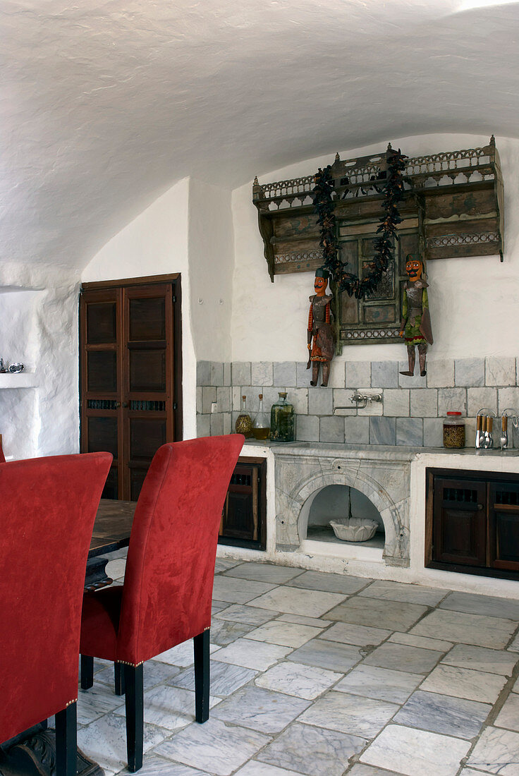 Essbereich mit roten Polsterstühlen, Maschrabiyya (dekorativer Holzgitter) mit maurischen Figuren über Waschbecken
