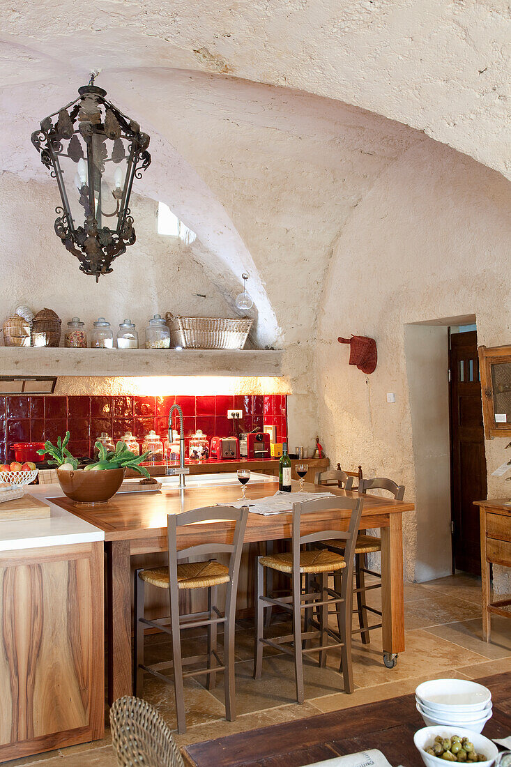 Rustic country-style kitchen with vaulted ceiling and red tiles