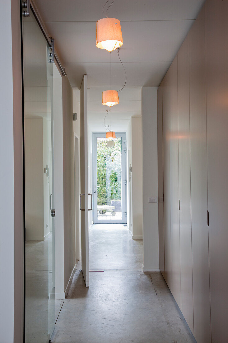 Bright hallway with pendant lights and glass door to the garden