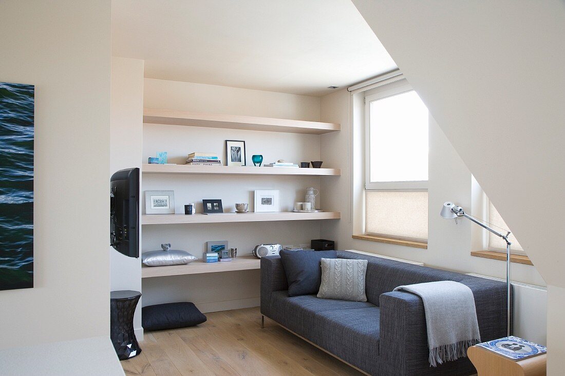 Comfortable, Scandinavian-style TV area with simple, grey designer sofa