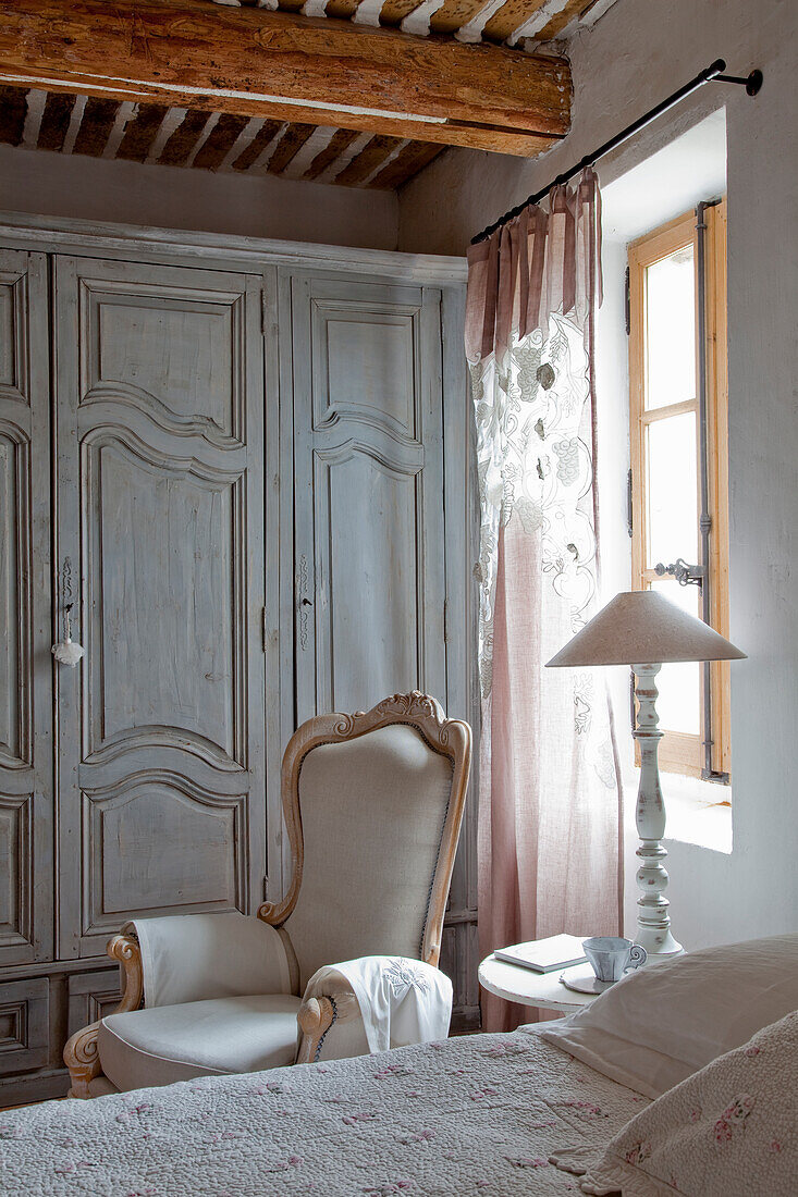 Vintage bedroom with wooden beamed ceiling and antique wardrobe