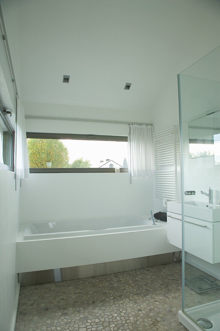 Designerbad mit eingebauter Badewanne vor Oberlicht