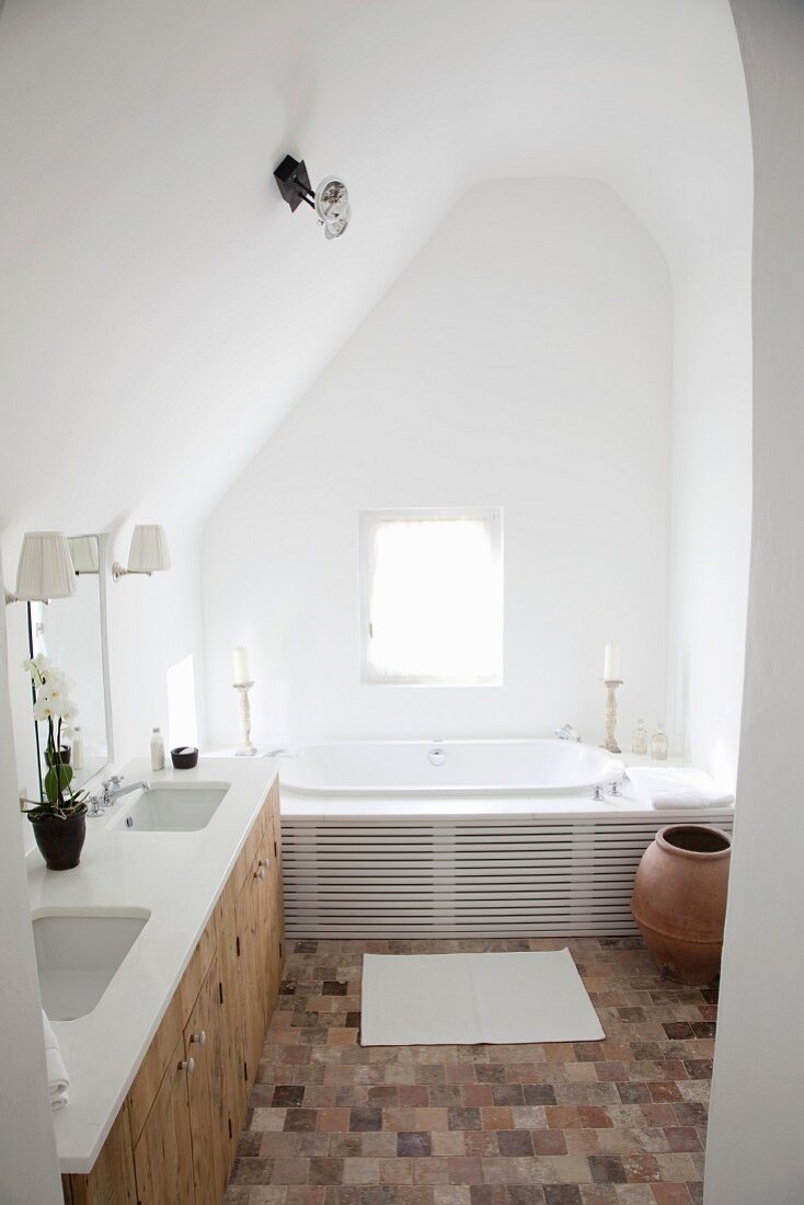 Renoviertes Bad in schlichtem Dachzimmer mit Terrakottaboden
