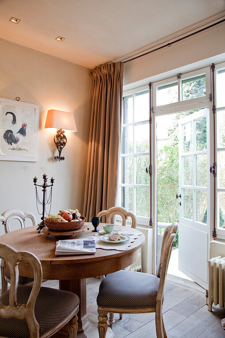 Traditional dining area with upholstered chairs next to open French door