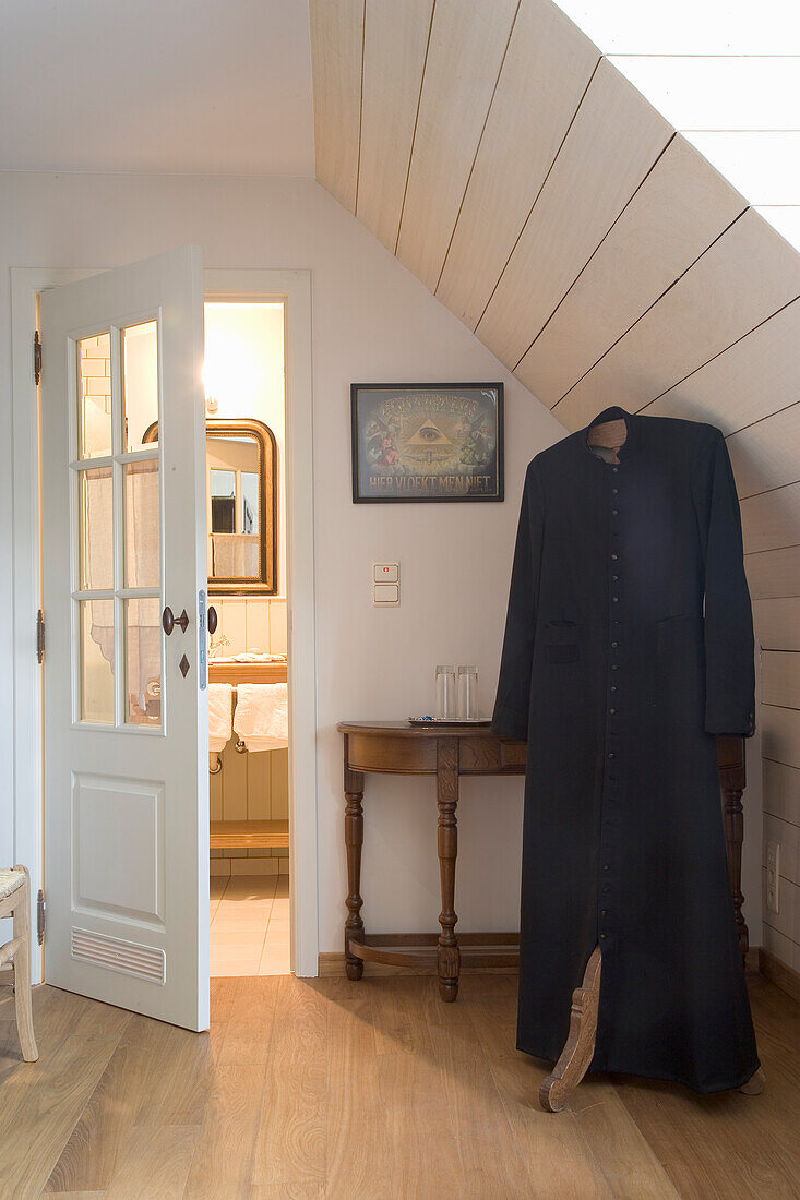 Hallway in the attic with wooden floorboards and coat rack