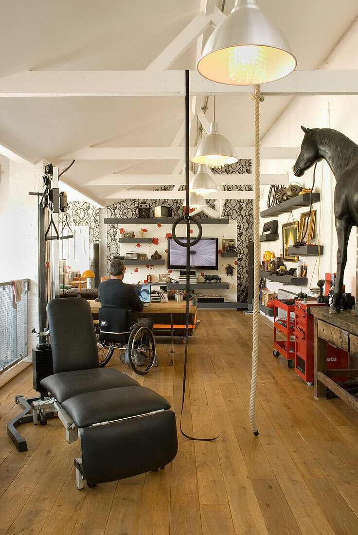 Work area with wheelchair user, workbench and fitness area