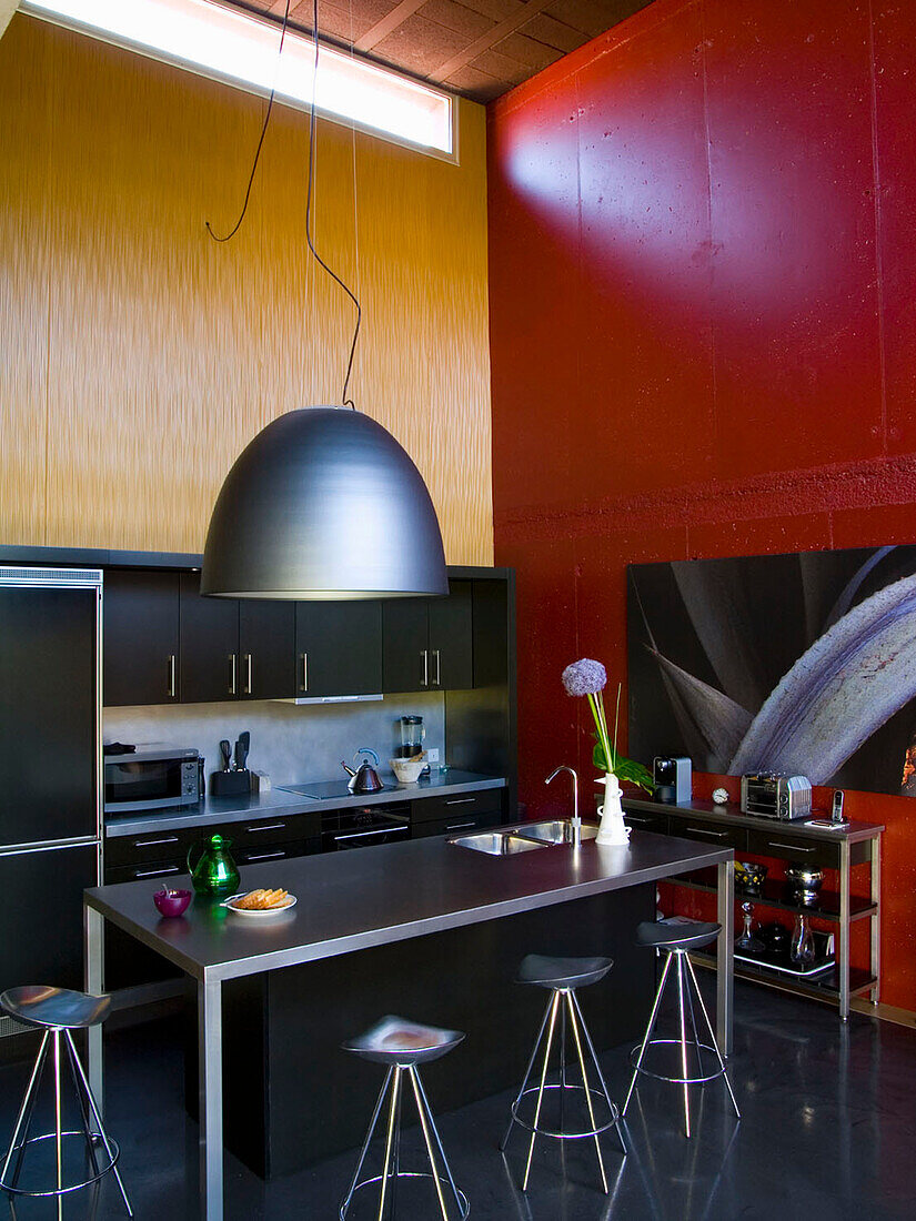 Moderne Küchenzeile mit industrieller Beleuchtung und kontrastreichen Farben