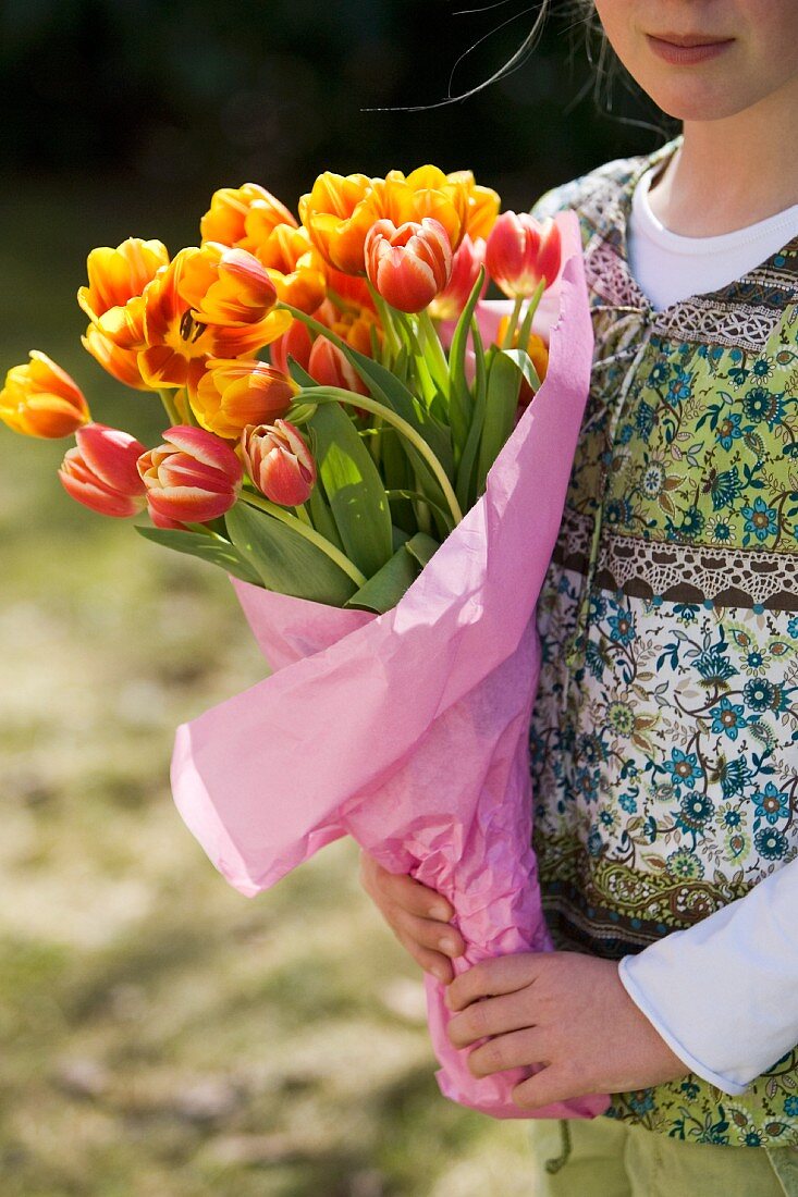 A girl holding a bunch of tulips