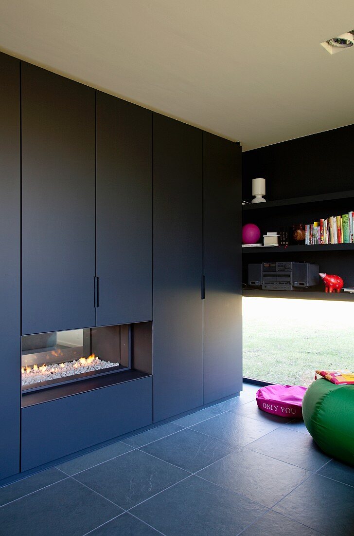 Black fitted cupboards with integrated fireplace