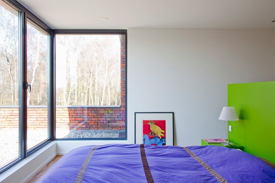 Schlafzimmer mit Panoramafenster und Blick auf sonniger Terrasse