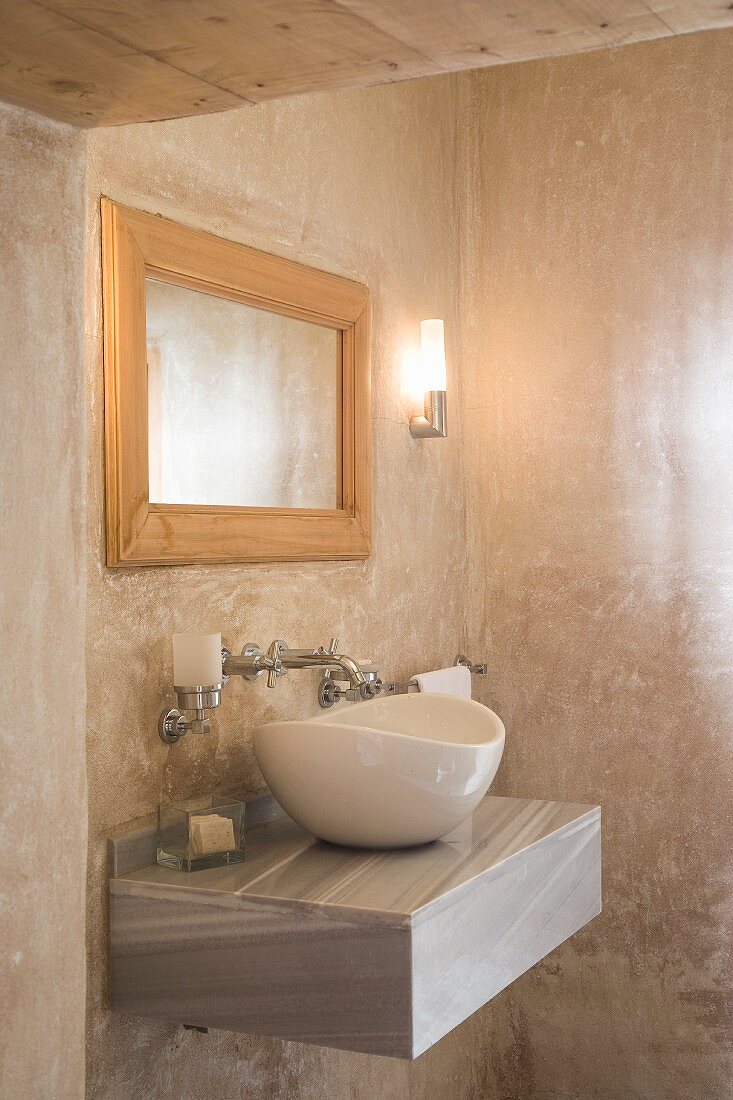 Marmorierte Wände im Badezimmer mit moderner, ovaler Waschschüssel auf Wandboard aus Naturstein