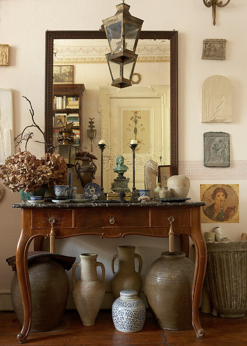 Antique console table with mirror, vases on the floor