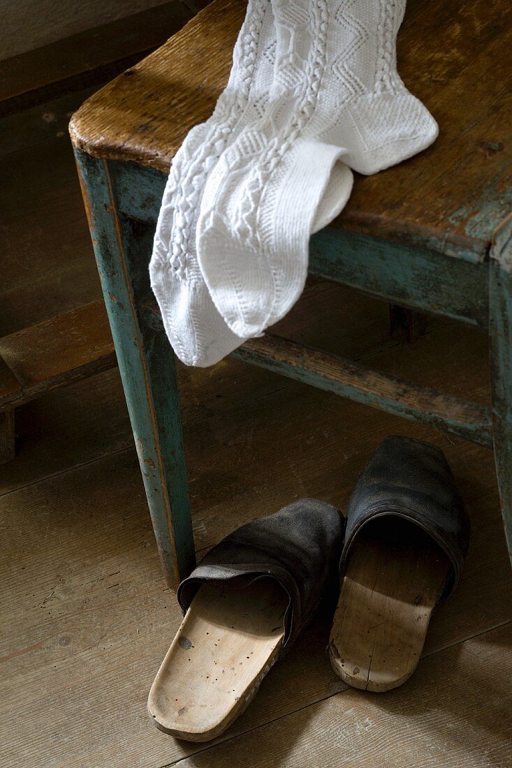 White knee socks on stool and old clogs on floor
