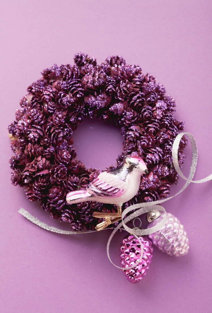 A Christmas wreath decorated with purple Christmas tree ornaments