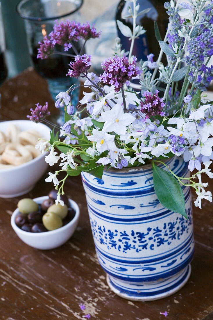 Gartenblumen in bemalter Keramikvase auf Holztisch