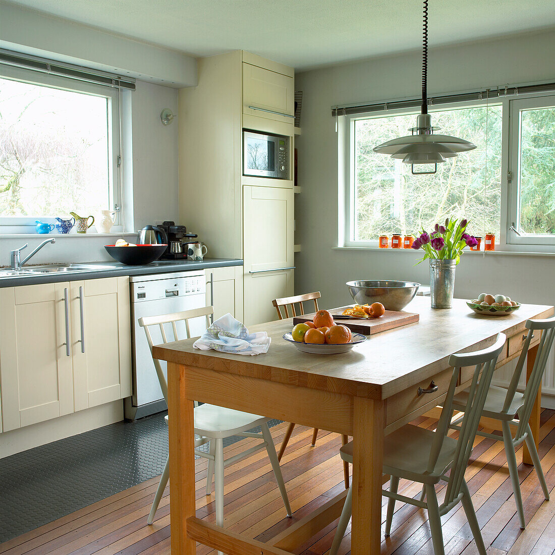 Heller Essbereich mit Holztisch und cremefarbener Küchenzeile