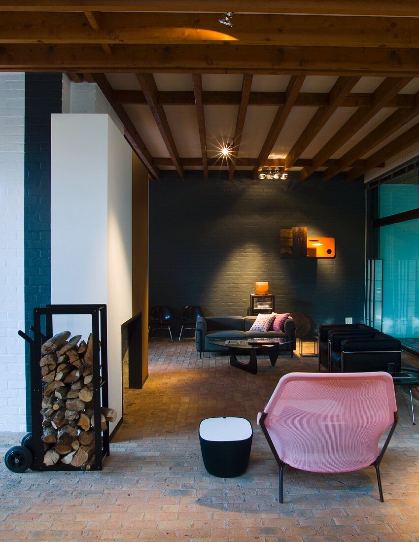 Stuhl aus rosafarbenem Kunststoff in modernem Wohnraum mit Holzbalkendecke