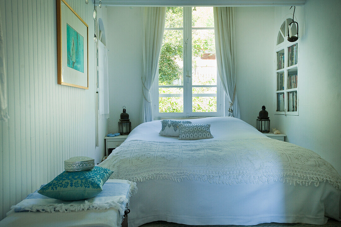 Schlafzimmer mit Fenster und weißen Vorhängen