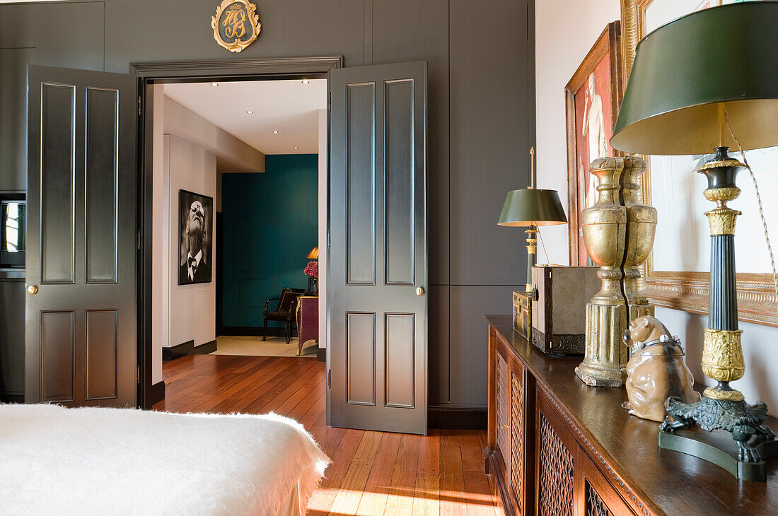 Bedroom with antique furniture and open double door to the living room