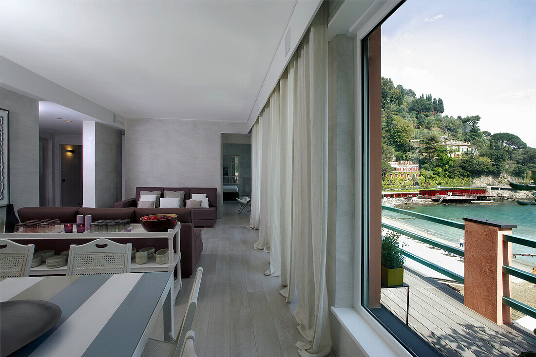 Open-plan living room with a view of the balcony and water