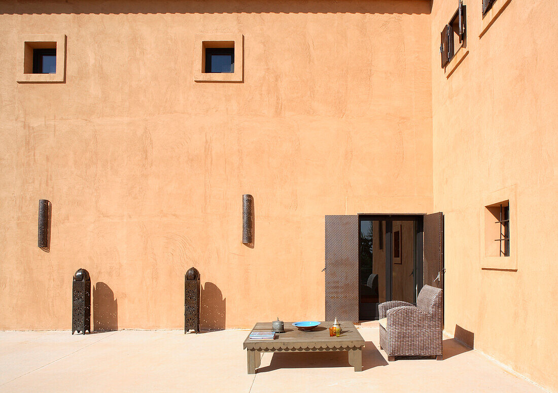 Moderne orientalische Architektur - Sessel vor niedrigem Tisch in einem versiegelten Innenhof