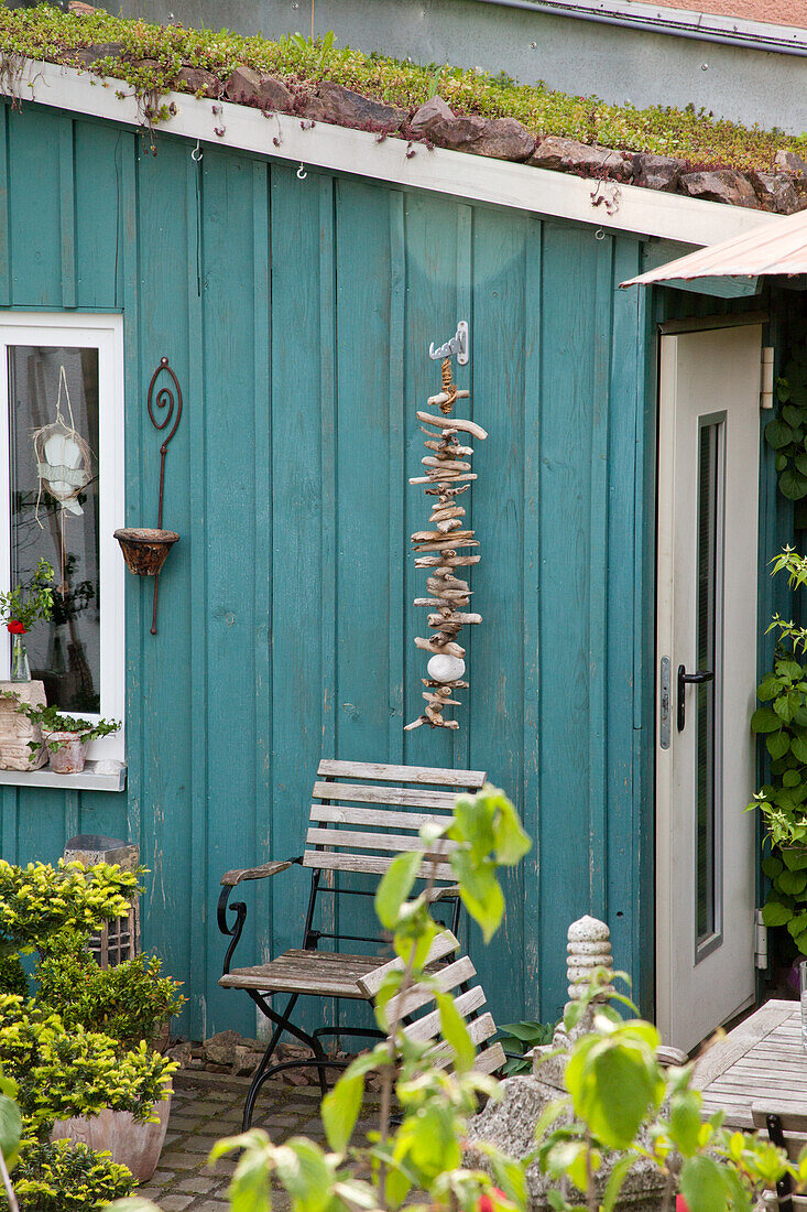 Turquoise garden shed with green roof and decorations