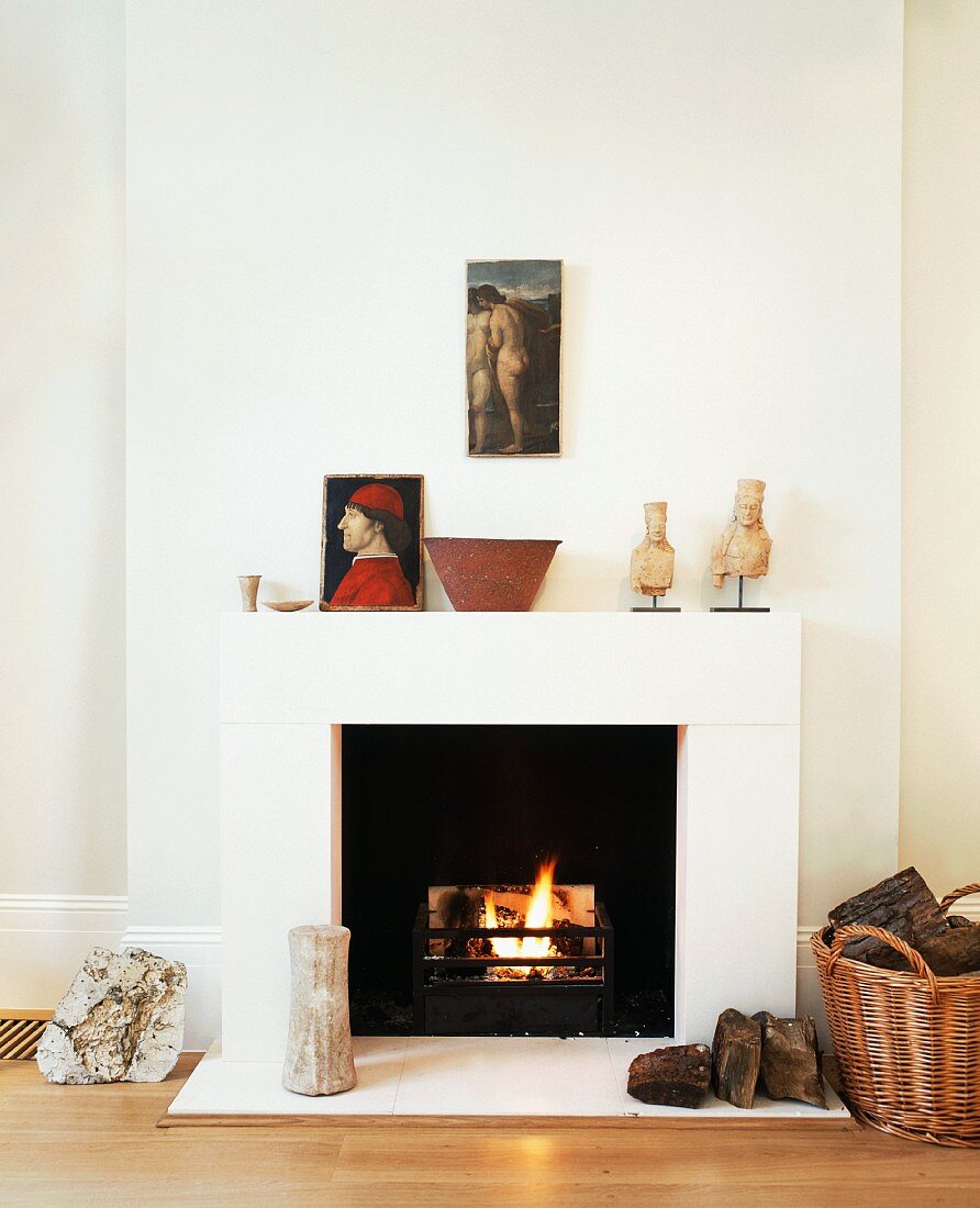 Fire in open fireplace in modernised, art collector's living room