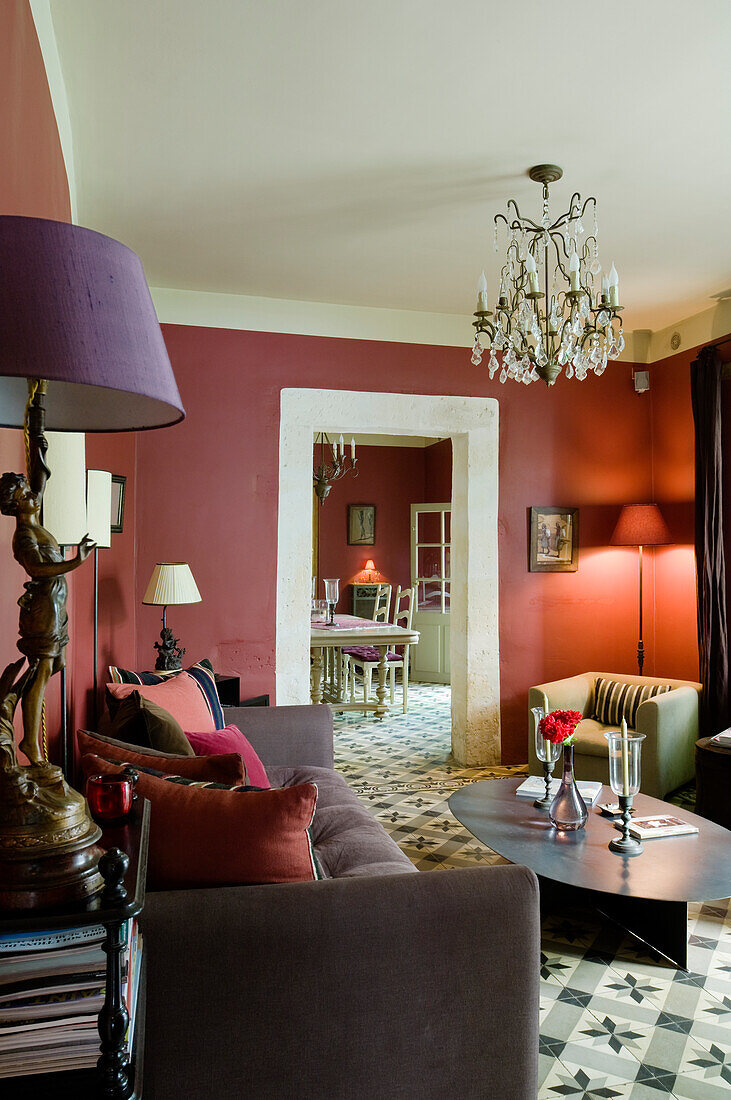 Living room with chandelier, red walls and patterned floor