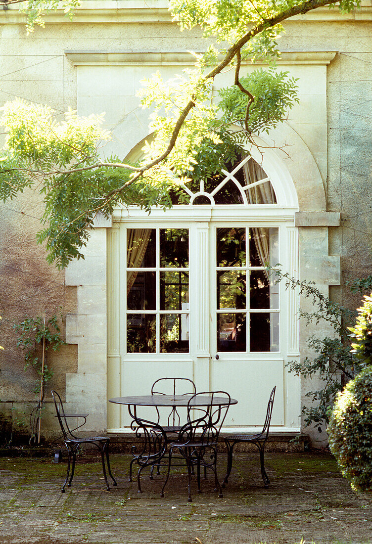 Garden furniture in front of historic house facade