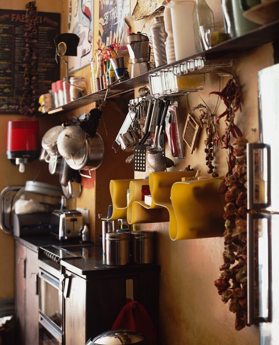 Corner of nostalgic kitchen with kitchen utensils under modern shelving