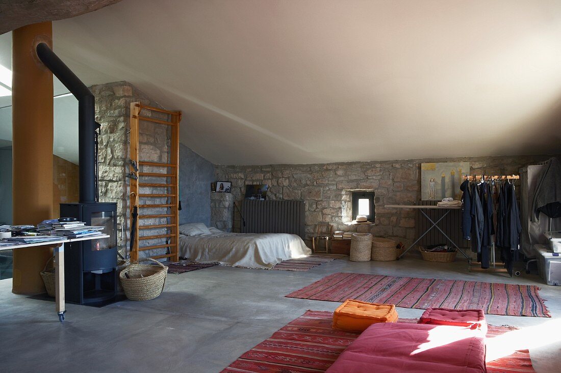 Schlafplatz in offenem Dachraum mit Natursteinwänden