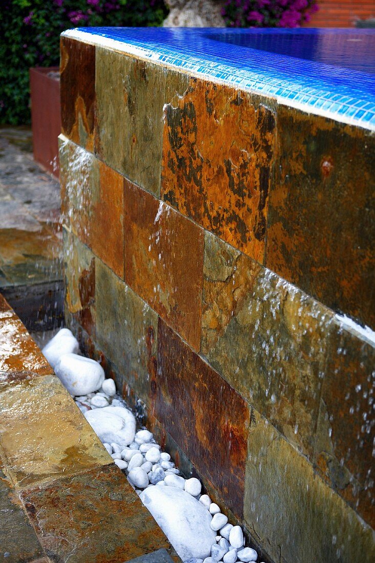 Stone tiles on exterior of negative edge pool