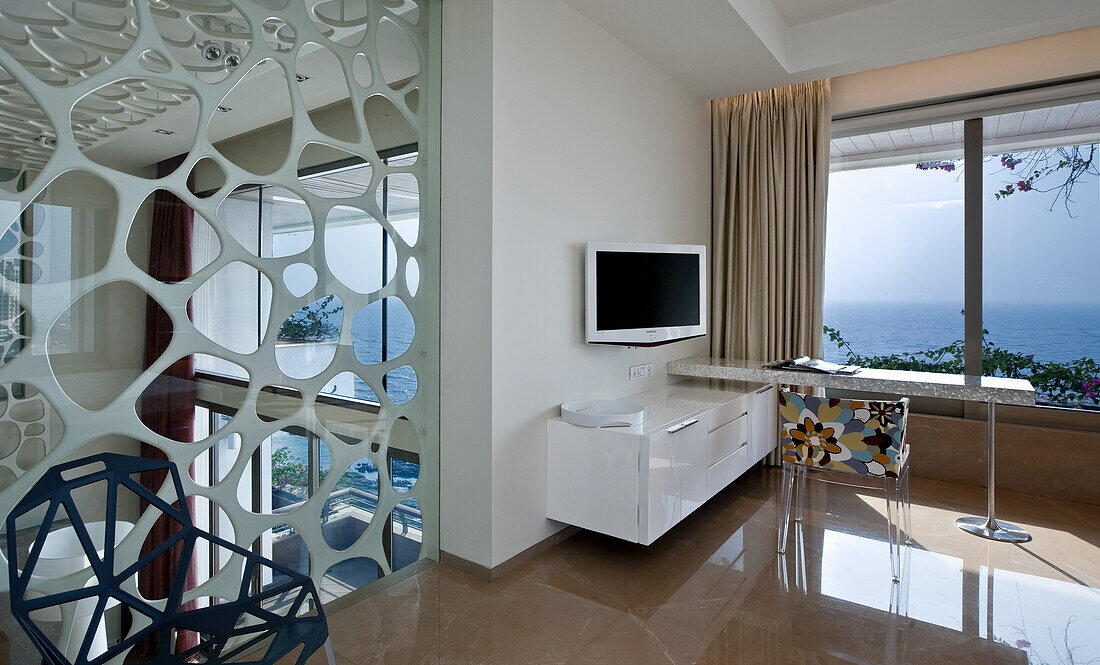 Modern living room with decorative partition wall, TV and sea view