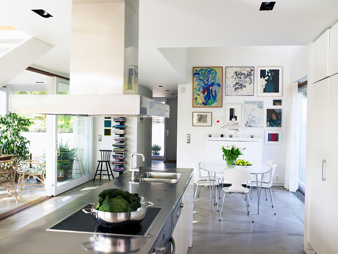 Modern kitchen with cooking island and dining area, art on the walls