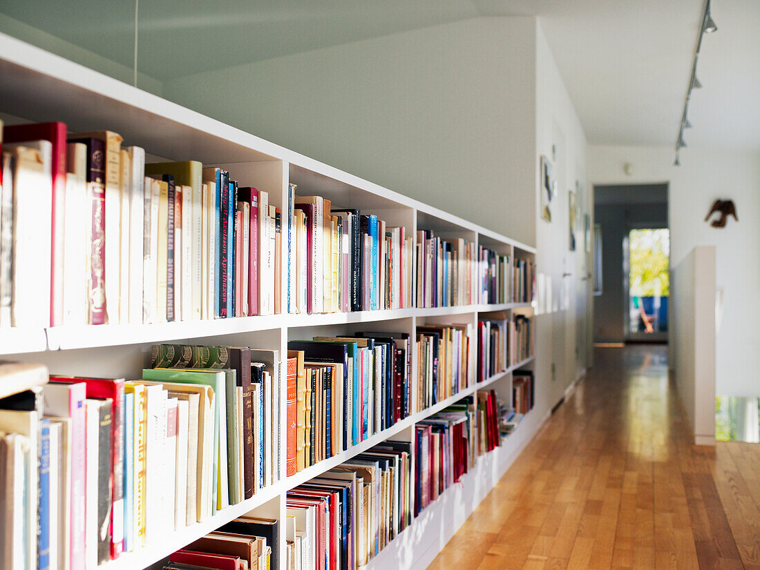 Weiße Bücherregale an der Wand in einem hellen Korridor