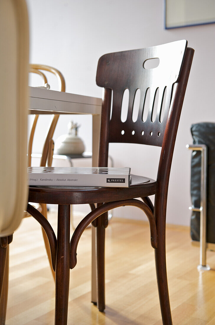 Wooden chair with book, table and wooden floor