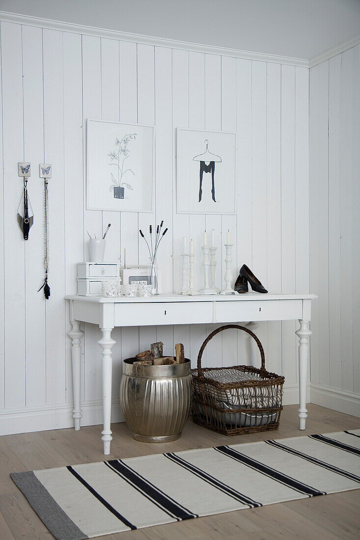 White console table with decorative elements in room with white paneled walls