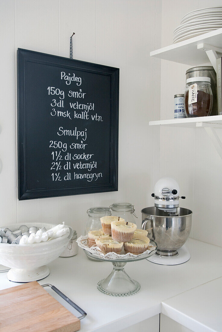 Kitchen corner with recipe board, mixer and cupcakes
